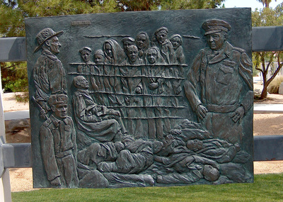 National Sculptors' Guild public art placement 27 The Desert Holocaust Memorial 1995 Memorial and Site Design by John Kinkade; Bronze sculpture by Dee Clements Palm Desert California The Desert Holocaust Memorial remains one of the National Sculptors' Guild's most important placements. We are so honored to be a part of this historic memorial that has provided a space for remembrance, education, and healing for people around the world since it's placement in Palm Desert, California in 1995. ​As you approach the Desert Holocaust Memorial, you see a circular row of trees. These trees represent life outside of the enclosed fence of the concentration camps. At the entry to the memorial you will see a bronze plaque which gives a chronology of the systematic deprivation by law of the civil rights, jobs, property and life of “non-Aryans” by the Nazi party. Inside the history pedestal is buried an urn containing the verified names of 12,000 Righteous Gentiles who hid or assisted those condemned by Nazi regime during the years of the Holocaust.  At the heart of the memorial are seven larger than life bronze figures representing the people and different aspects of the Holocaust. The standing man is intended to be defiant and accusing. He in part represents the resistance of the Jews and others that fought the Nazi tyranny. (Note the left forearm on this man bears the number tattooed on a local Holocaust survivor.)  The other figures are of a mother with two children begging for mercy, a boy from the ghetto, a rabbi praying, and finally the figure behind the group, a man alone, silent, dying. His death represents bigotry, ignorance, and hatred taken to its inevitable end.  The faces and representations at the memorial were taken from actual photographic and news footage researched by the artist's team at the United States Holocaust Museum in Washington D.C.  The seven bronze figures are mounted on a double-tiered Star of David 20 feet across. The block granite is etched with a map of Europe indicating the location of the many concentration camps as well as the number of persons who perished.  The cobblestone and light standards are replicas of those at Auschwitz. Placed between the light posts are eleven bas reliefs telling the story of the Holocaust. A plaque located adjacent to each details the specific scene represented. ​ This memorial includes extensive provisions for educating people of all ages, races, and religions about the period of the Holocaust. It is a lesson about denial of basic civil rights. The monument memorializes lost parents, children, loved ones, and millions of innocent people. It is a place of respect, of respite, of mourning and of remembrance. It is also a monument of hope -- hope that we can overcome bigotry and live among diversity in peace. -Desert Holocaust Committee.