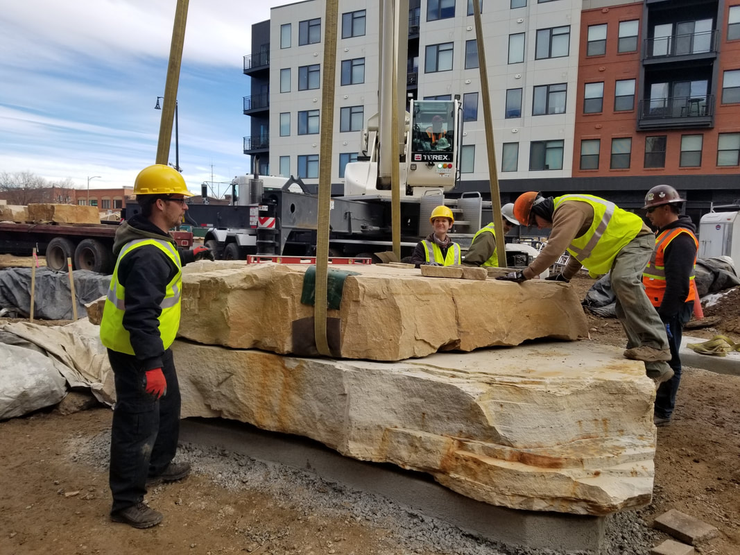 Update 11/16/2018: Today was a huge step in the installation of The Legacy Project. Over 68,000 lbs of Dakota sandstone was craned into the site and set by Denny Haskew and the National Sculptors' Guild. Next week the final stone and bronze element will be placed.  The Rotary Club of Thompson Valley's 