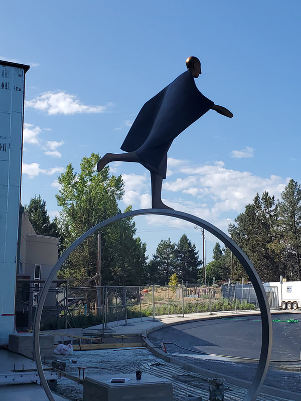 Installed Today! The National Sculptors' Guild completed installing Carol Gold's bronze sculpture "Time" in Bend, Oregon earlier today. Below are some images from the installation.

"Time" depicts a stylized figure running atop a large wheel, alluding to travel, as well as, the ceaseless movement of the clock. The implied motion of the sculpture reflects the energetic and playful mood of city life.
​
The bronze figure measures 6 feet high, 4.5 feet wide and 3.5 feet deep. The 7-ft diameter circular ring will be fabricated from rectangular rolled stainless steel tubing. 

More images to follow once landscaping is complete. 