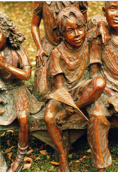 National Sculptors' Guild public art placement 36 Jane DeDecker's Snapshot multicultural figurative bronze sculpture Oxnard, California 1995 "Snapshot" by Jane DeDecker and the National Sculptors' Guild was placed in Oxnard, California in 1995.   ​Snapshot was originally commissioned by Michael Jackson, The multi-figure bronze depicts a number of children ready for the camera, sitting on a bench with a wagon pulled up to one side; the kids are in a casual pose, enjoying a respite from summer play, holding toys and drinking a soda. It even includes the pouting kid in the back - not wanting to be pictured as often happens. The piece is universal even though it was inspired by photos Jackson gave DeDecker.   NSG Public Art Placement 36