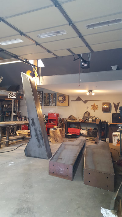 10/25/17 Update: Fabrication is nearing completion. We will be heading to Little Rock for installation soon. 4/23/17: We're pleased to announce that NSG's Stephen Shachtman won this year's Sculpture at the River Market public art competition. Stay tuned to see it actualized and installed at the Southwest Community Center. This sculpture represents a culmination of parts forming a stronger, more impactful unit as a result. The graphic nature of the sculpture is ideal for both ease of viewing while in motion and creating an iconic sculpture for the Community Center campus. Because this site incorporates so many activities and houses several public buildings, the convergence of this is represented in this form - a central piece acts as the hub of all the opportunities the campus offers. At the heart of the three steel forms is a sphere representing the community. The Steel/Bronze portion of the “A” represents Arkansas. While the individual pieces of the flagstone sphere make up my notion its people. Fabricated in CorTen steel, with a Bronze cap at the point of each pillar. The tallest form measures approximately 16-feet high. The overall footprint will span approximately 10ft wide. The center sphere is composed of stacked flagstone pieces which create the stepped sphere form. (Not a perfect smooth sphere, but stepped to create sphere appearance.) The sphere structurally helps connect the three legs, which are then bolted into cement piers. I recommend contextualizing the artwork within the broader site by placing it in a large gravel circle of grey breeze, and planting karl foerster grasses within.