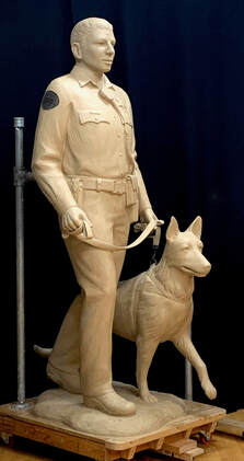 Update 12/1/2022: The K-9 Unit is nearly finished in clay! It's exciting to see all the elements coming to life for this special project. Update 11/7/2022: Gary Alsum has finished sculpting the Female Deputy Sheriff in clay. She's off to the foundry to begin the bronze casting process. Update 5/26/2022: The Hardscape Design Elements have been refined and the stone is ordered. Lettering will be etched into several tons of granite for this placement. 2/18/2022: You may not realize, but monumental placements start small. On this one, we went REAL SMALL. John created a model of the site with our proposed layouts for the city to choose from.  We've just been approved on our design for the City of Cerritos' First Responders Plaza which will be located in front of the Sheriff's Department. Our design team is transforming the 2500 sq ft lawn into an artful gathering space that honors first responders.  Three monumental bronze sculptures by NSG's Gary Alsum will be the focal point of our Tribute to Public Safety. Granite walls will be adorned by quotes and insignia. A memorial will be placed to pay tribute to the city's fallen officers. And a Bosque of Trees forms a nurturing space to house the new 9/11 memorial. The entire site becomes a piece of art. We are really pleased with the design and how this will enhance the community.  We are looking forward to sharing the process here, stay tuned.